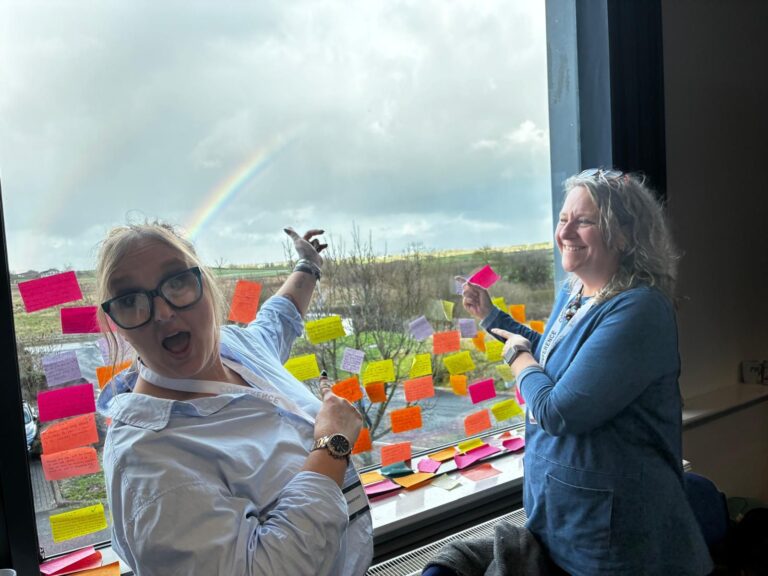rainbow with post-its on window.